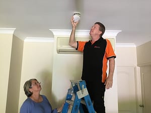 scott from glasshouse home safety inspecting a fire alarm